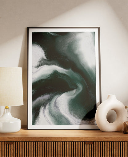 Framed contemporary abstract artwork "Measured Against" from the Infinite Studio series by Nicole Potrich featuring deep green and white fluid marble-inspired abstraction exploring comparison and emotional tension. Artwork on a wooden console.