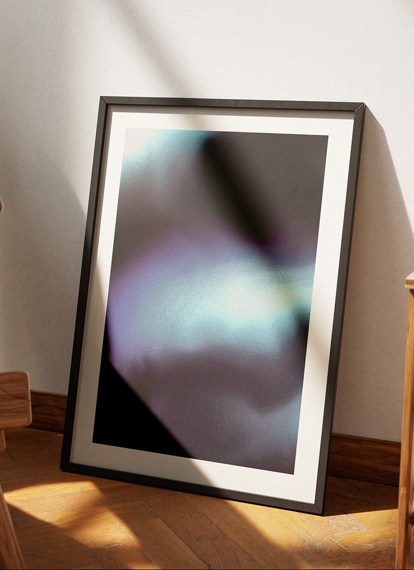 Framed contemporary abstract artwork "Crossing Over" from the Infinite Studio series by Nicole Potrich featuring deep blue and cyan fluid abstraction with layered marble-inspired textures leaning against a wall in a cozy room.