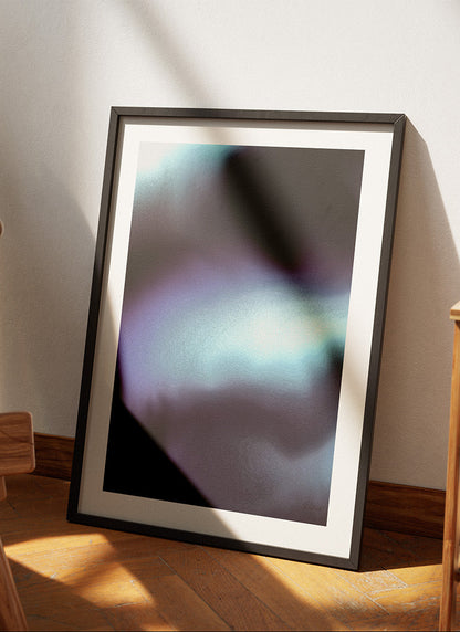 Framed contemporary abstract artwork "Crossing Over" from the Infinite Studio series by Nicole Potrich featuring deep blue and cyan fluid abstraction with layered marble-inspired textures leaning against a wall in a cozy room.