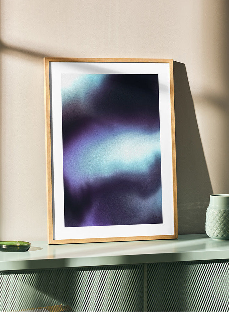 Framed contemporary abstract artwork "Crossing Over" from the Infinite Studio series by Nicole Potrich featuring deep blue and cyan fluid abstraction with layered marble-inspired textures on a teal cupboard.